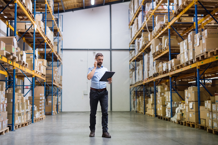 94452524 - warehouse worker or supervisor with a smartphone.